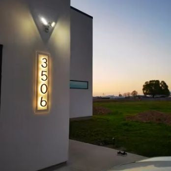 Modern house exterior with illuminated house numbers at dusk