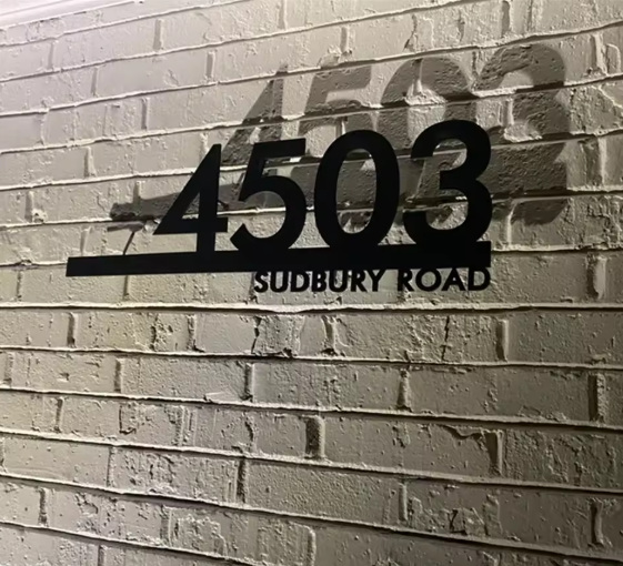 floating metal address sign 4503 Sudbury at night with shadows